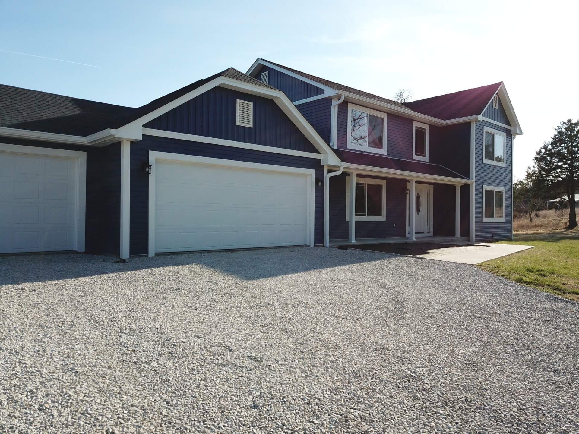 A large blue house with a white garage door