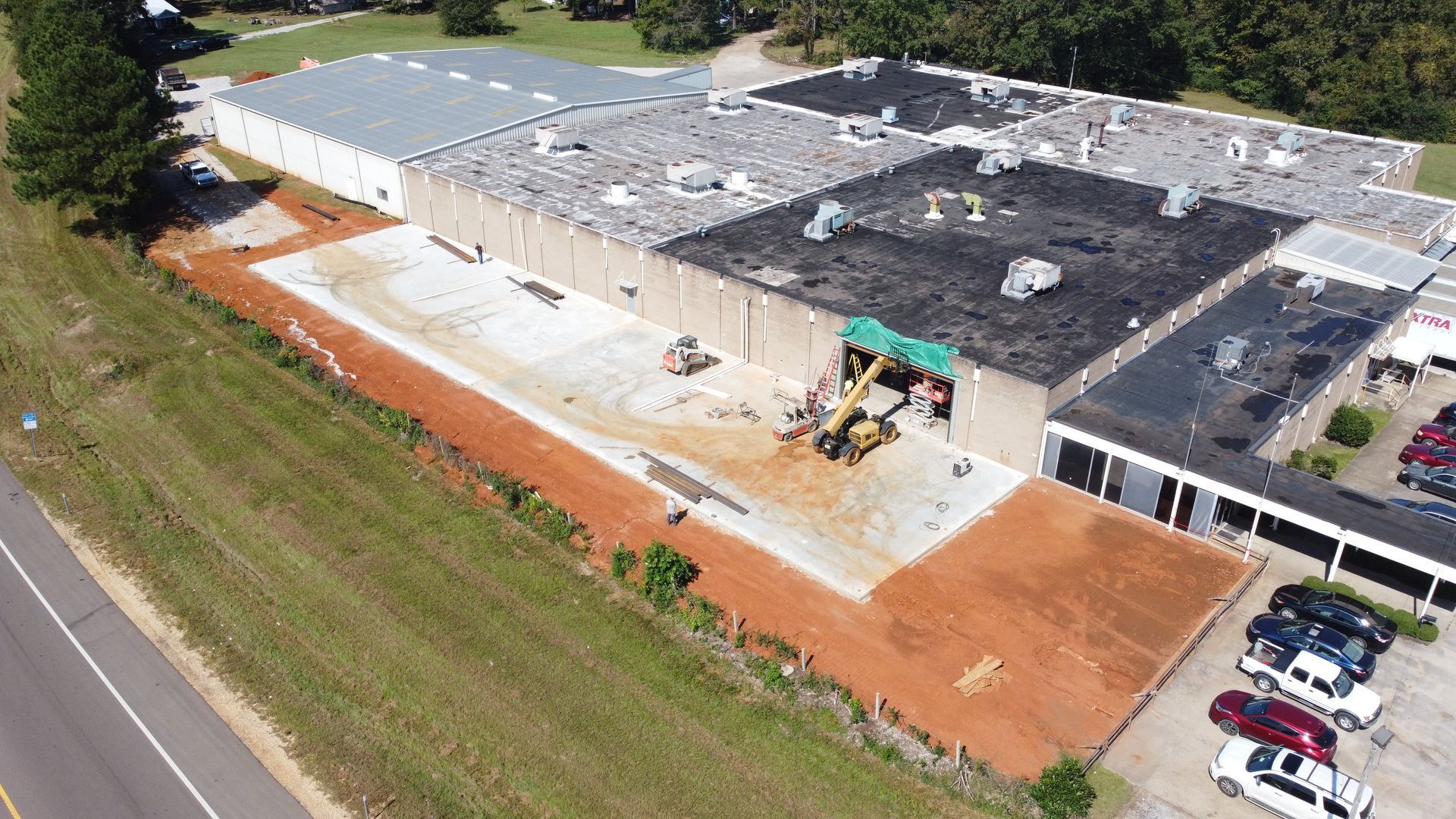 An aerial view of a large building under construction next to a road.