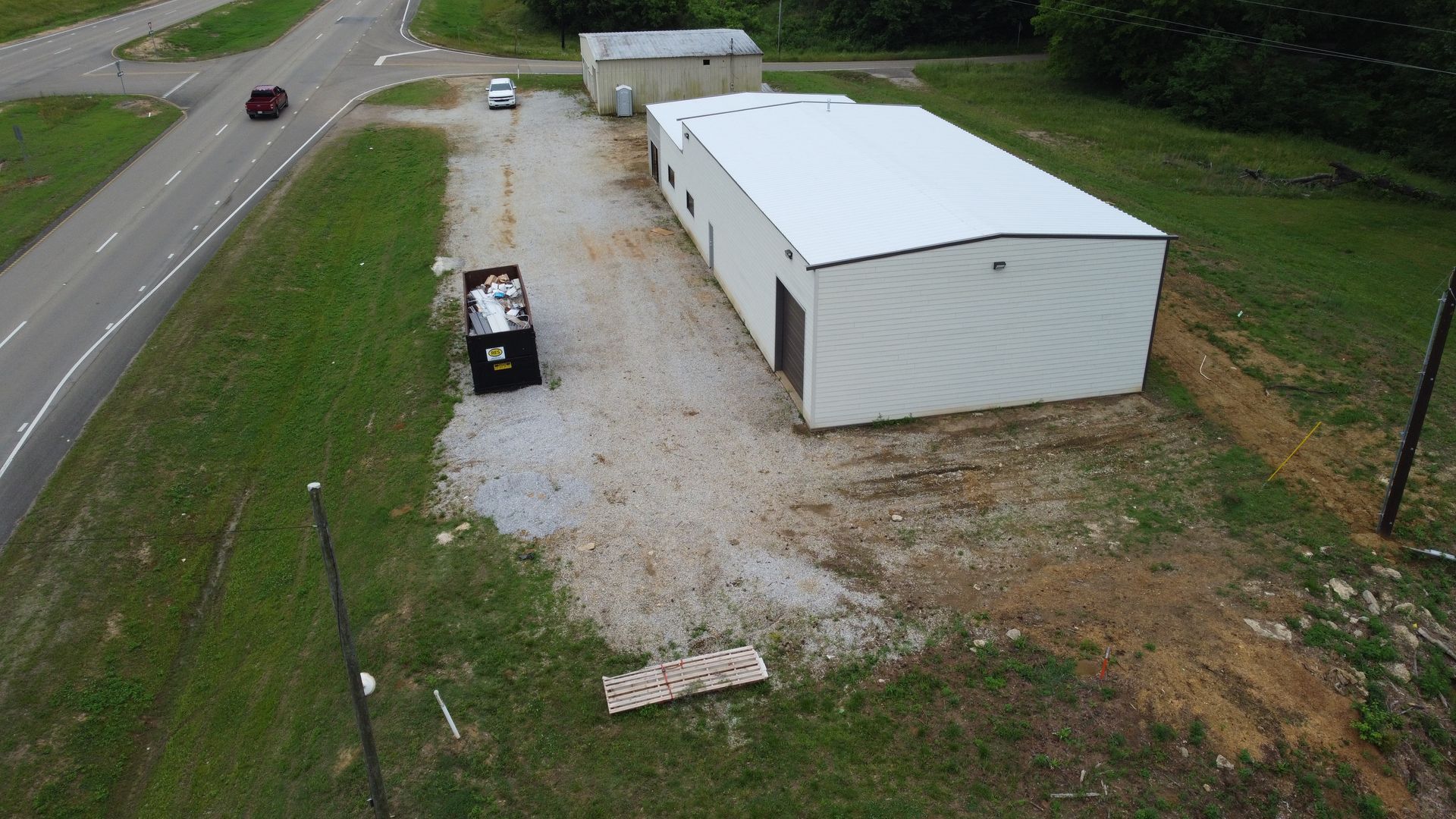 An aerial view of a large white building next to a road.