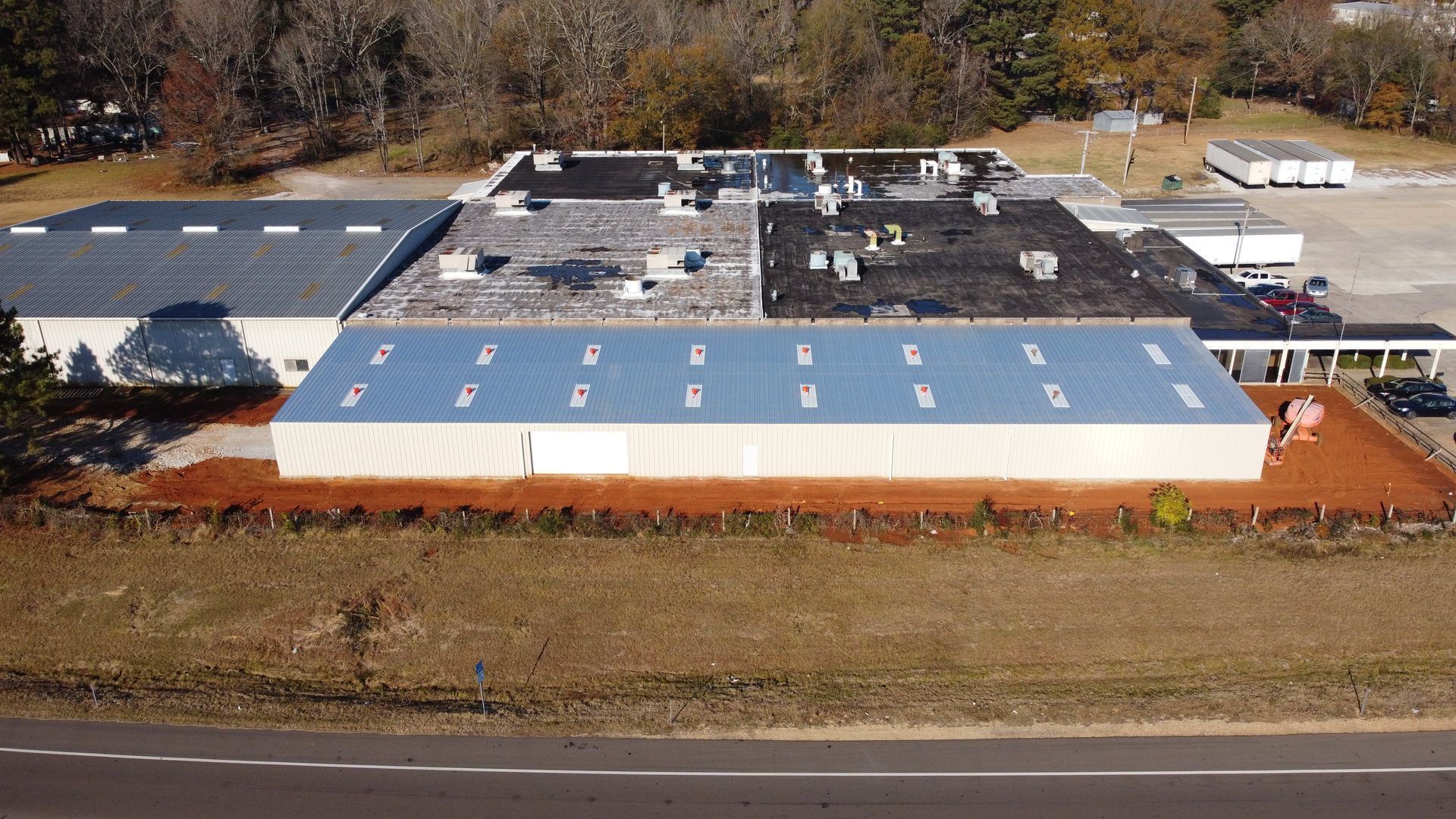 An aerial view of a large building with a roof that has a lot of windows.
