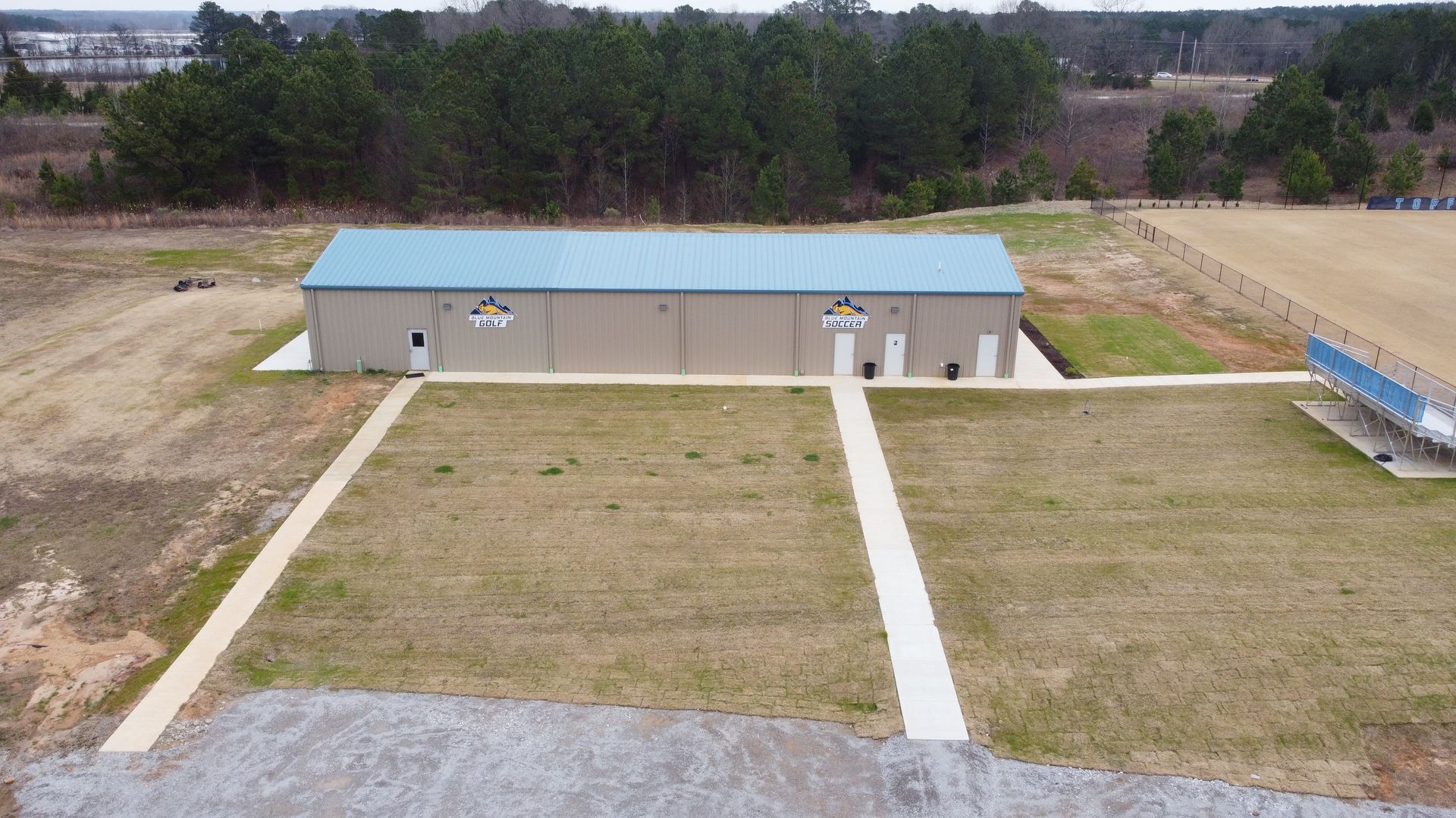 An aerial view of a large building in the middle of a field.