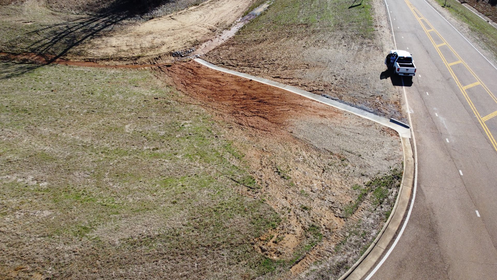 An aerial view of a car driving down a curvy highway.