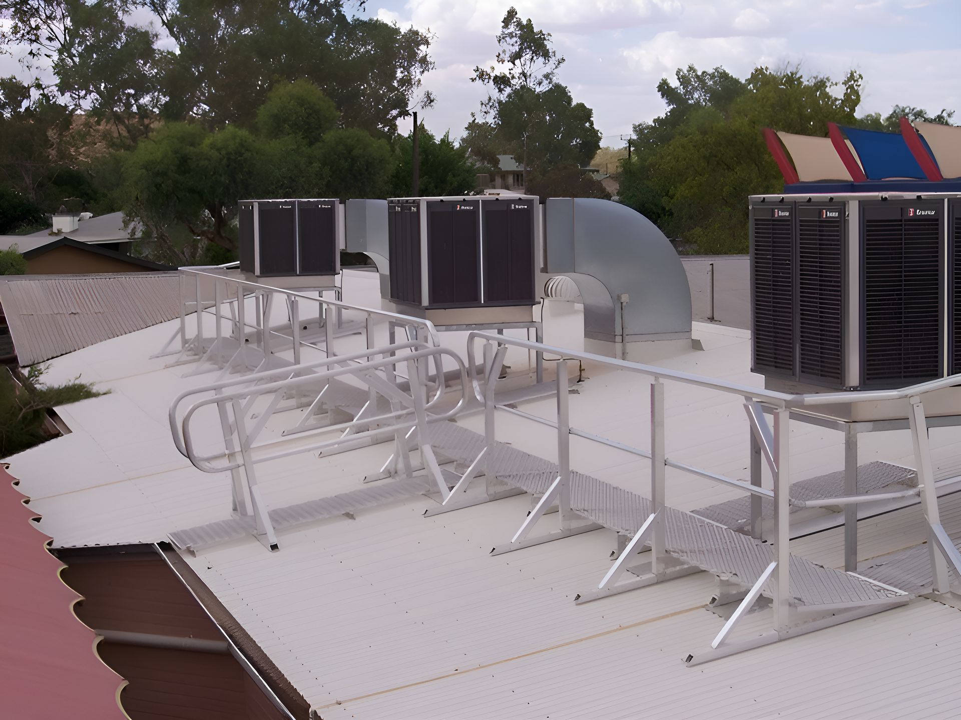 A Row Of Air Conditioners On Top Of A White Roof — Sno's Welding In Ciccone, NT