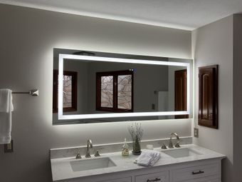 Modern bathroom vanity with large backlit mirror, double sinks, and neutral gray walls