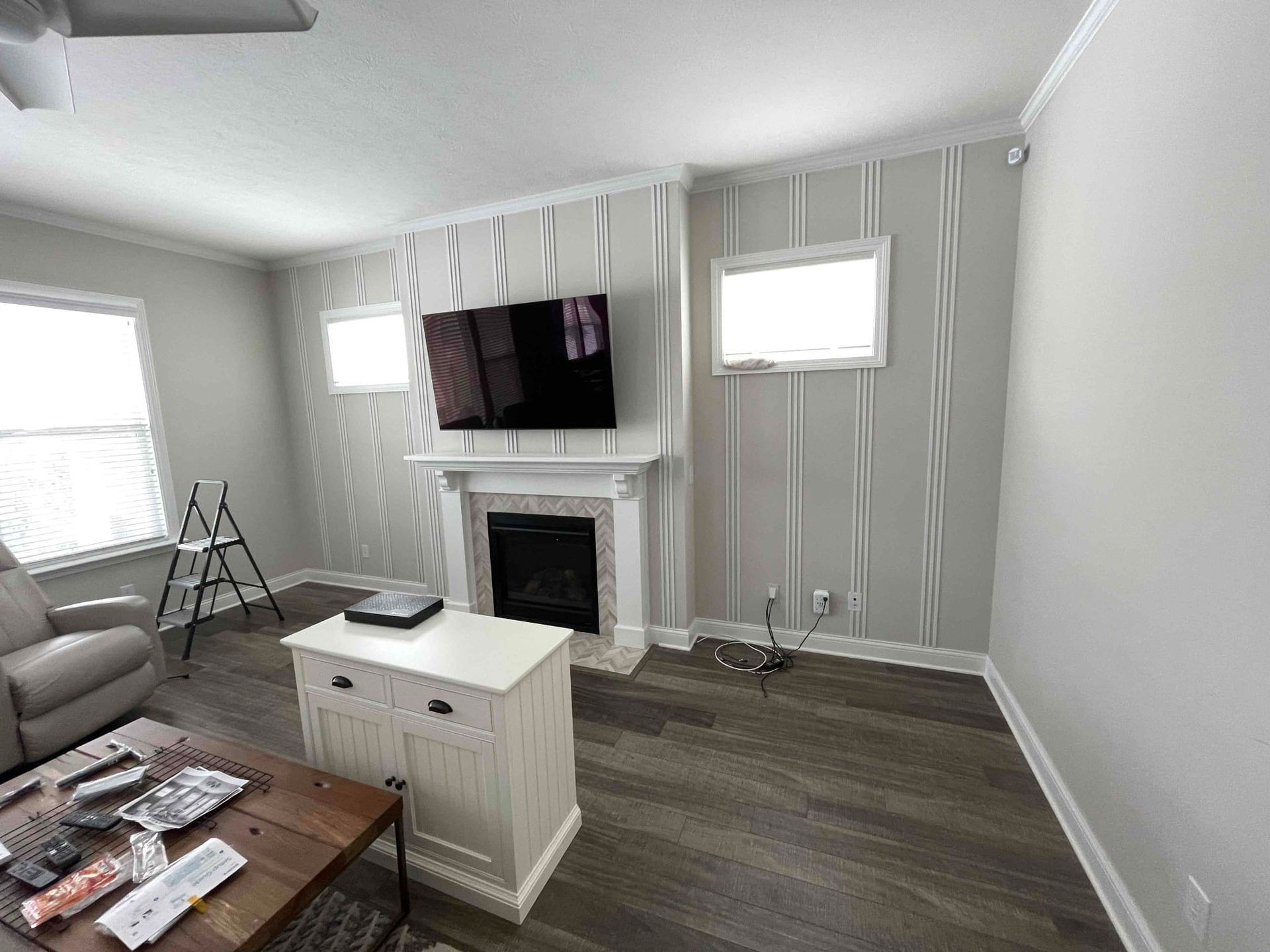 Bright living room with gray walls, fireplace, wall-mounted TV, sofa, and coffee table