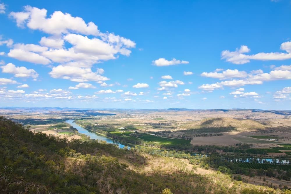 A View Of A River Flowing Through A Valley Surrounded By Mountains And Trees — South Burnett Truck Rental In Gayndah, QLD