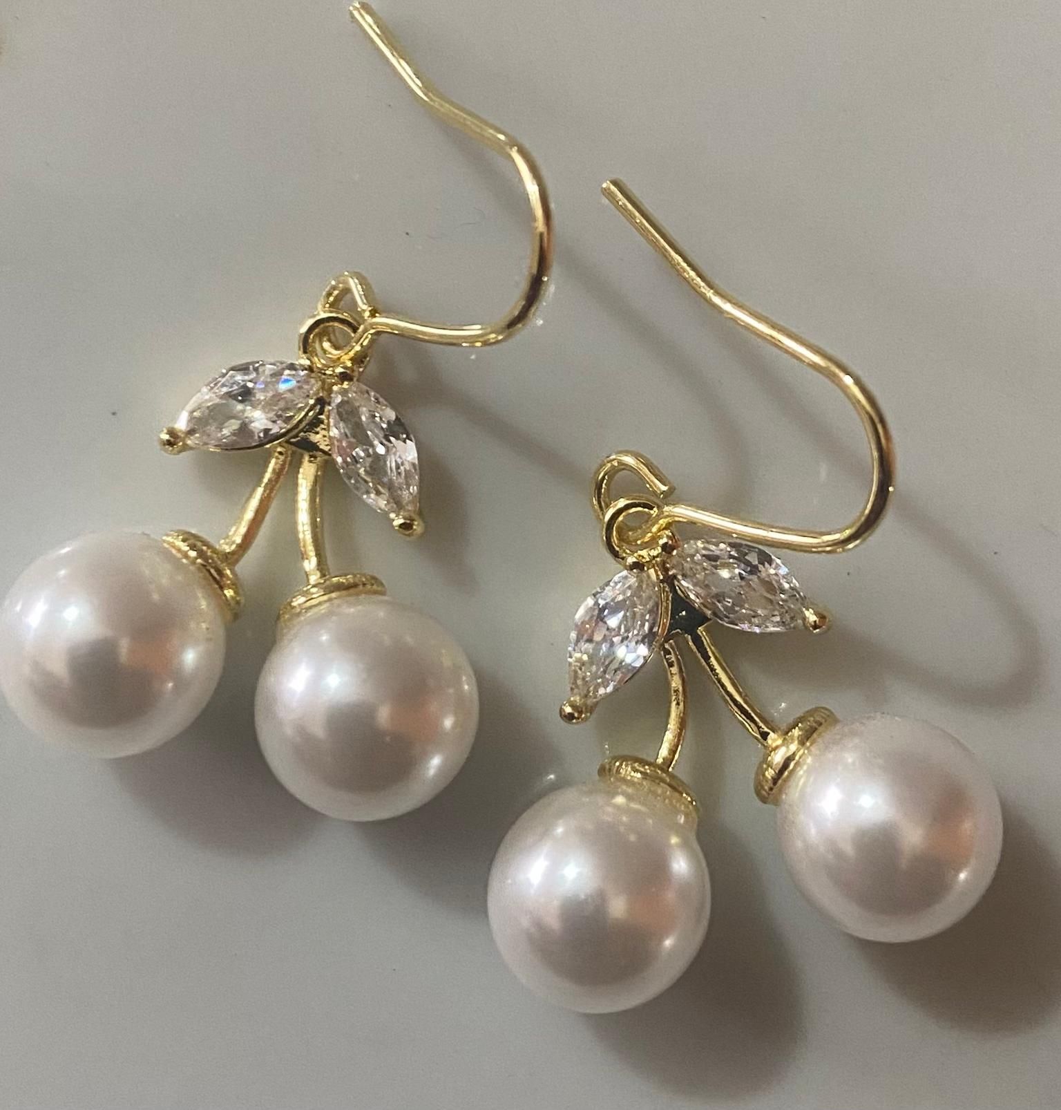 Un par de pendientes con perlas y pedrería en forma de cerezas.