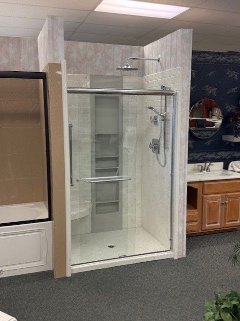 A bathroom with a walk in shower and a sink.