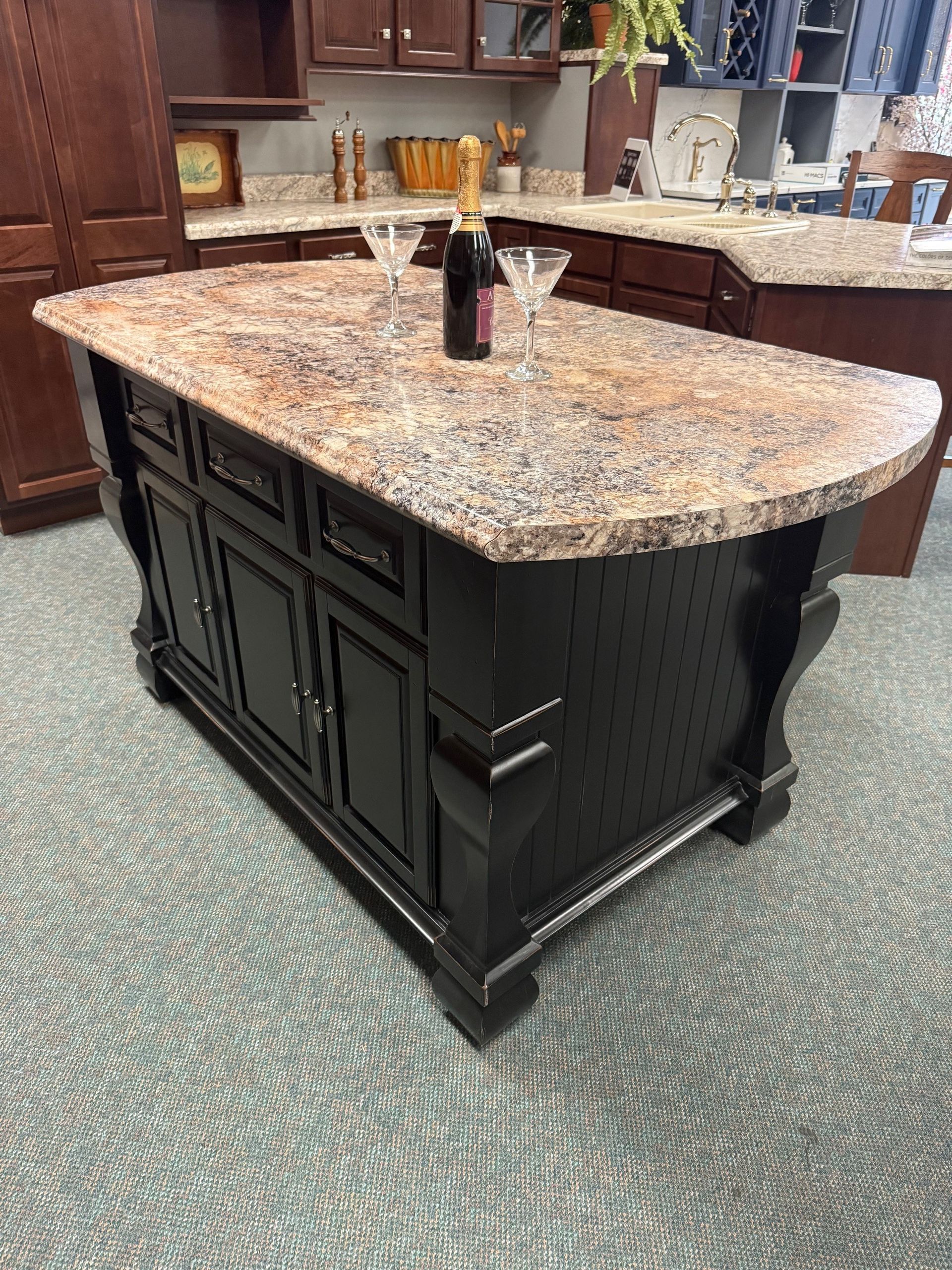 A kitchen island with a bottle of wine and two martini glasses on it.