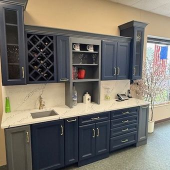 A kitchen with blue cabinets, a sink, and a wine rack. A kitchen with blue cabinets, a sink, and a wine rack.