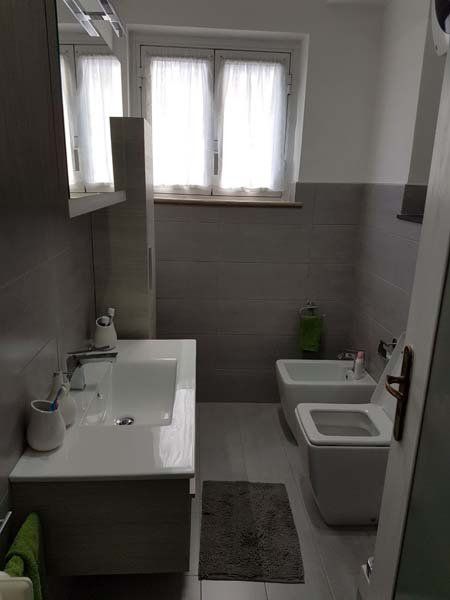 bagno moderno con lavabo, bide, asciugamani e finestra