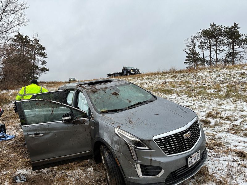 A car is sitting in the snow on the side of the road.