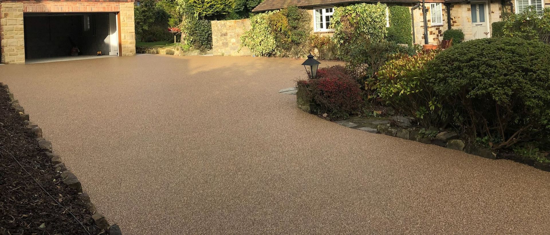 A gravel driveway leading to a house with a garage.