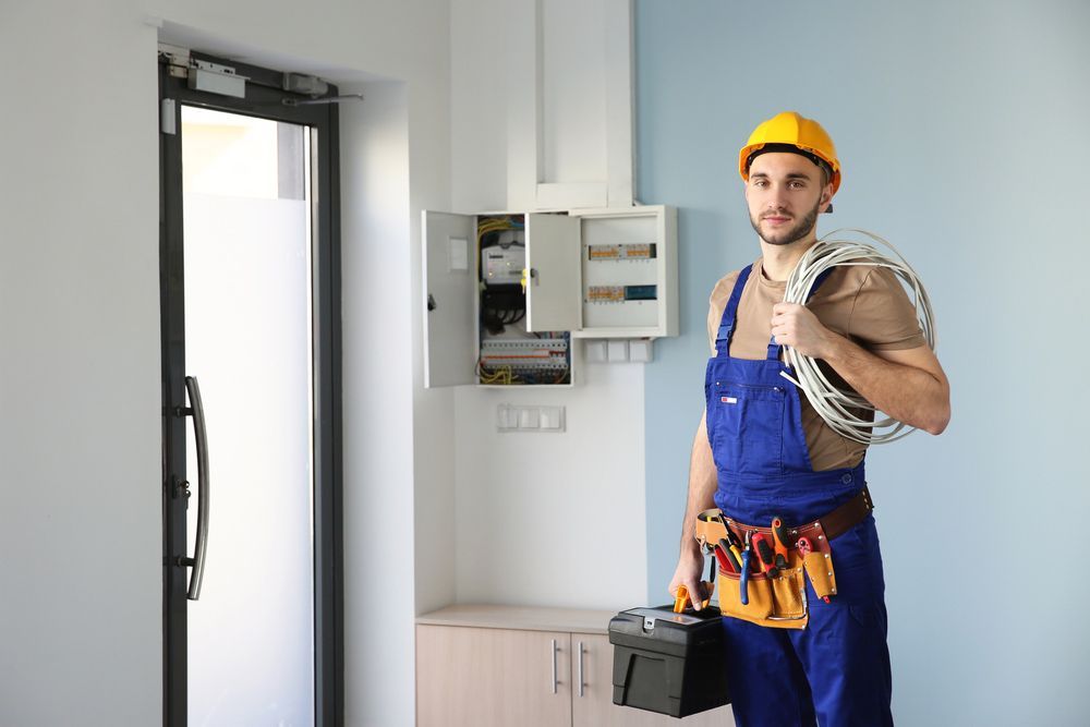 Electrician with bunch of wires indoors — Level 2 Electrician Near Me in Newcastle NSW