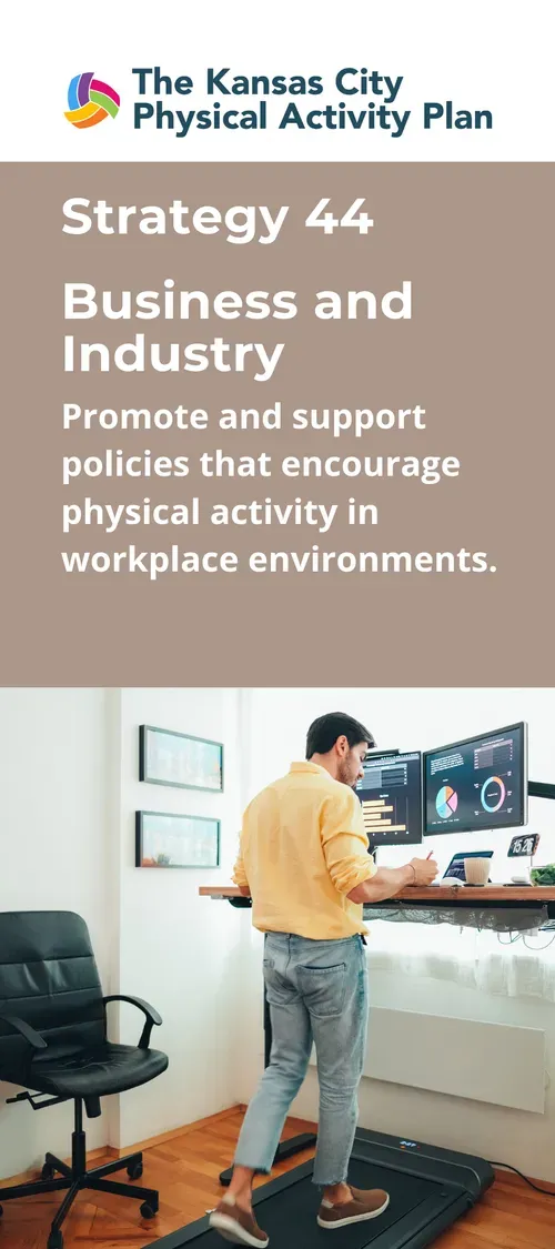 A person walks on a treadmill while working at a standing desk in an office.