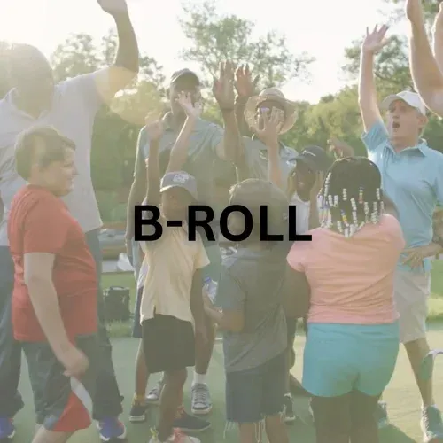 Group of people, including children, with hands raised in celebration outdoors, with 