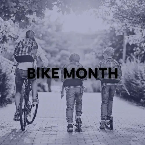 People biking and using scooters on a paved path in a park; 