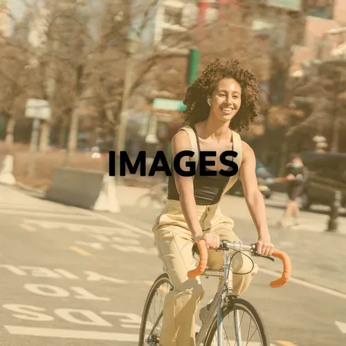 Woman on a bicycle smiles while riding in the city, sunny day.
