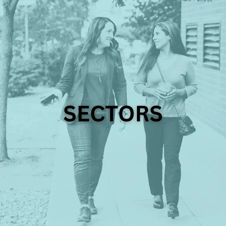 Two women walking and talking outdoors; text overlay 