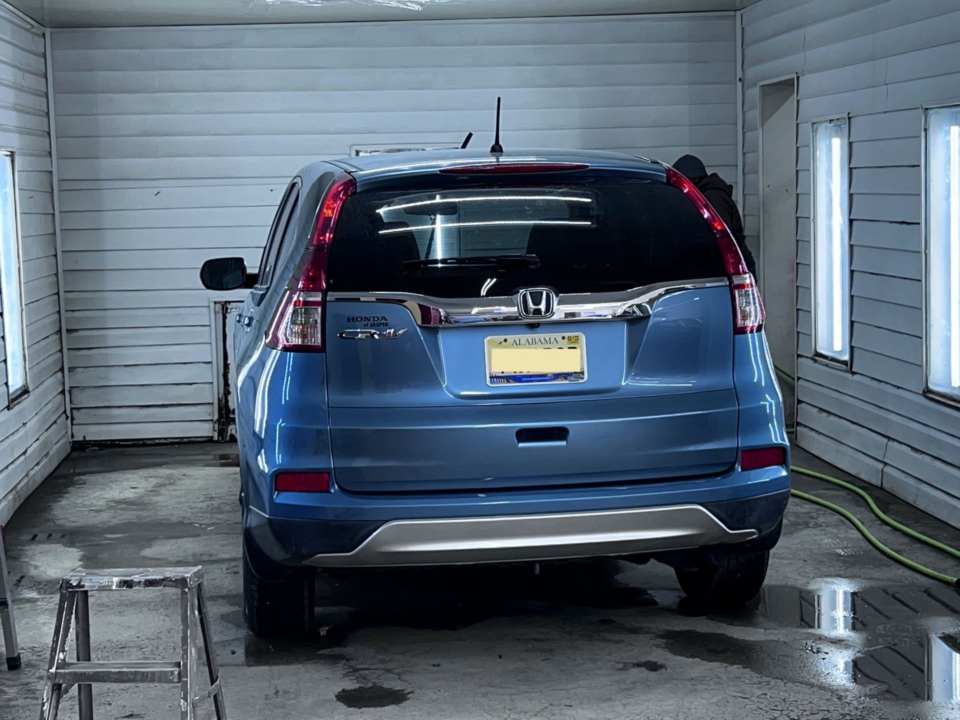 A blue honda cr v is parked in a garage