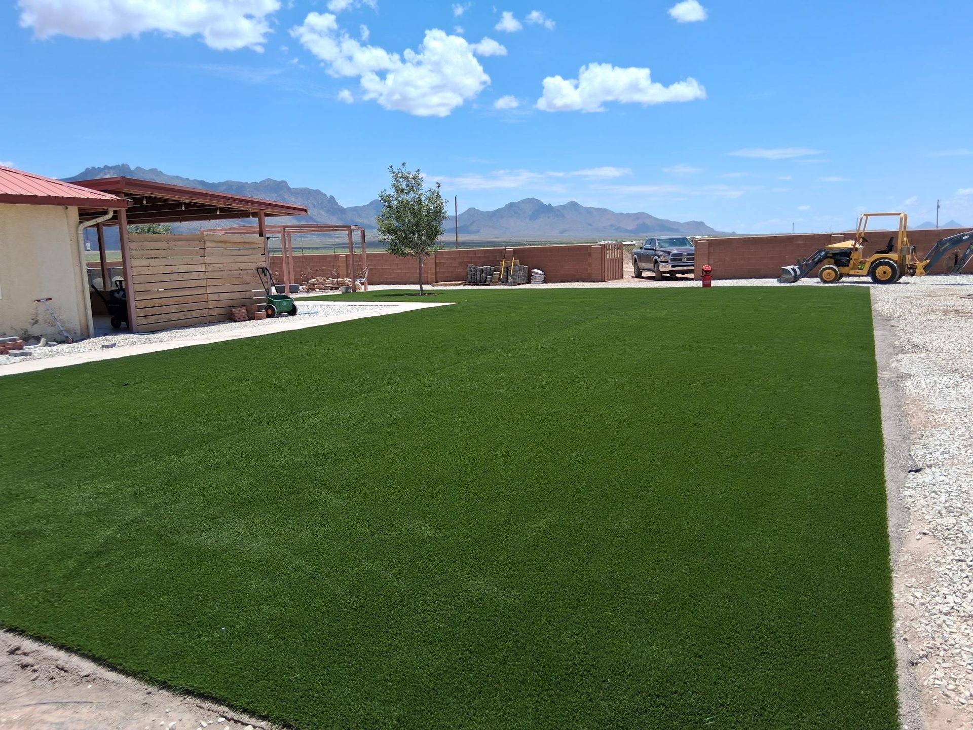 A lush green lawn with mountains in the background