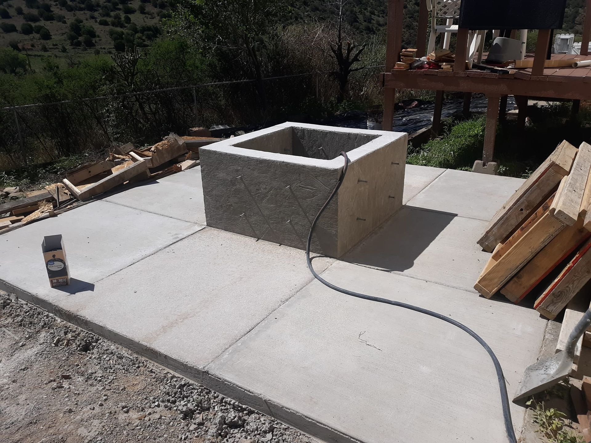 A fire pit is being built on a concrete patio