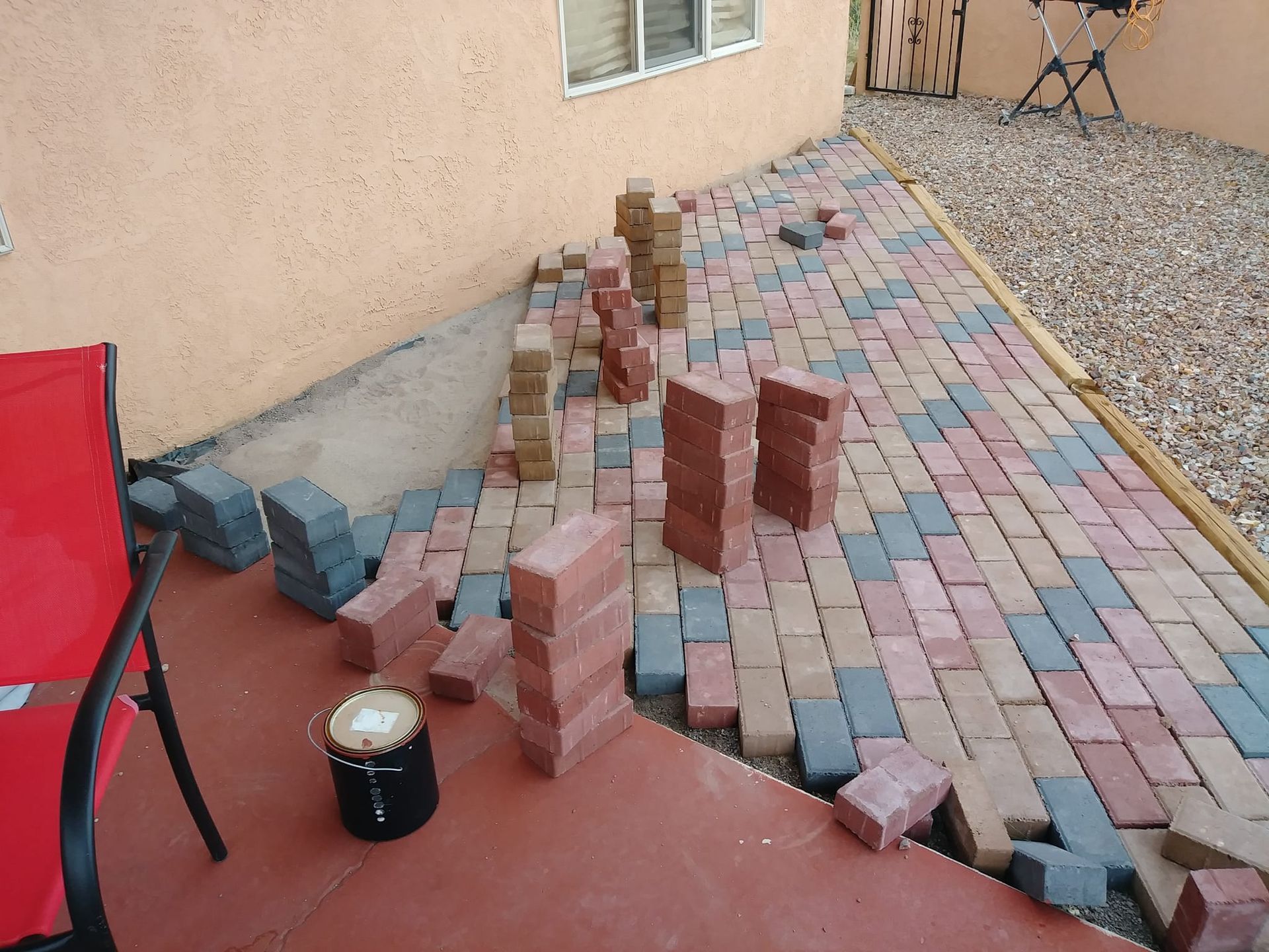 A brick walkway is being built in front of a house