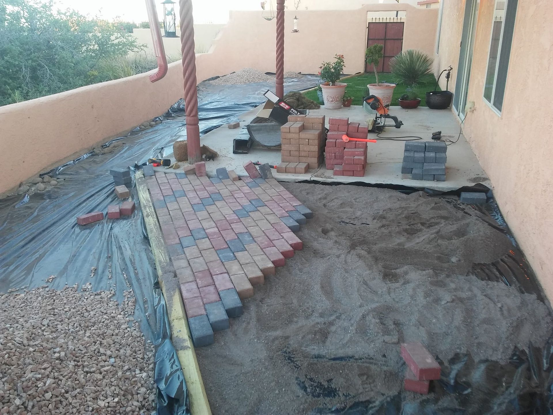 A brick walkway is being built in front of a house