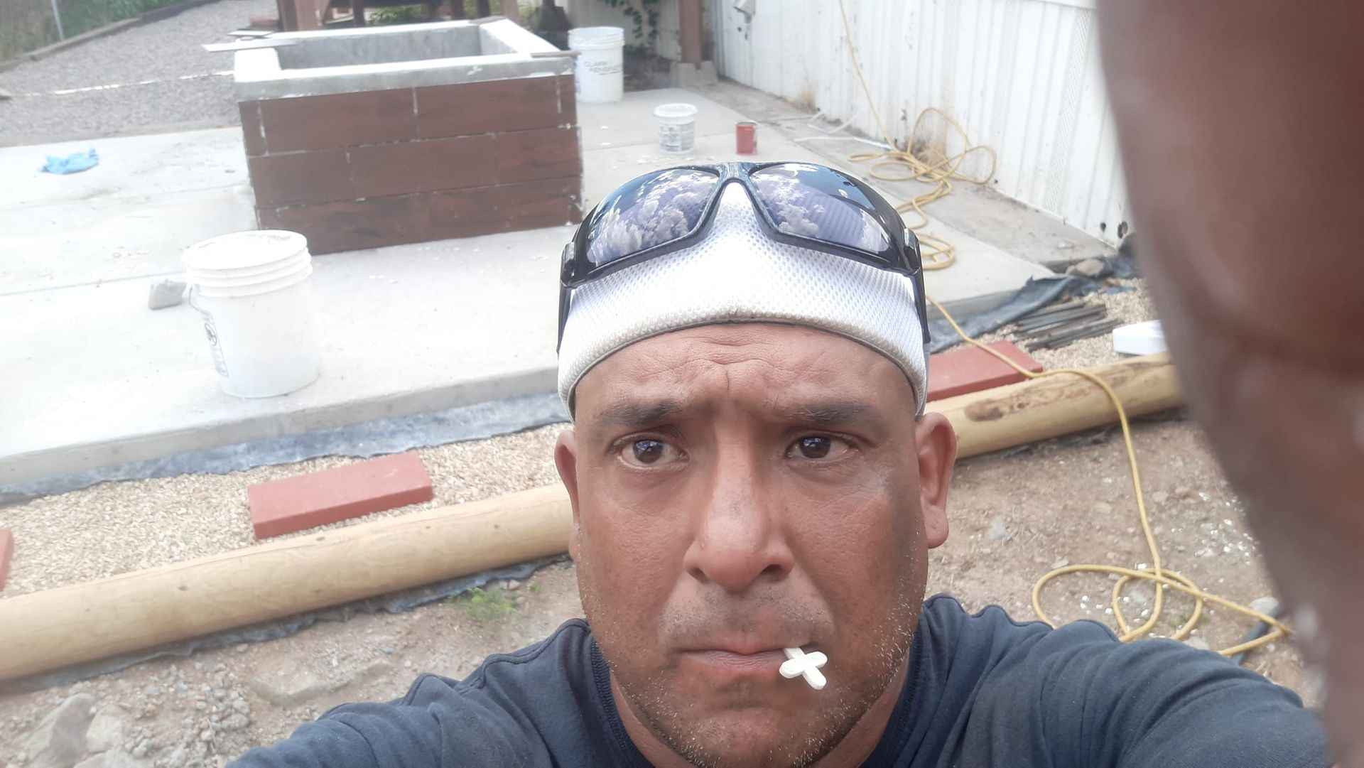 A man wearing sunglasses and a headband is taking a selfie.