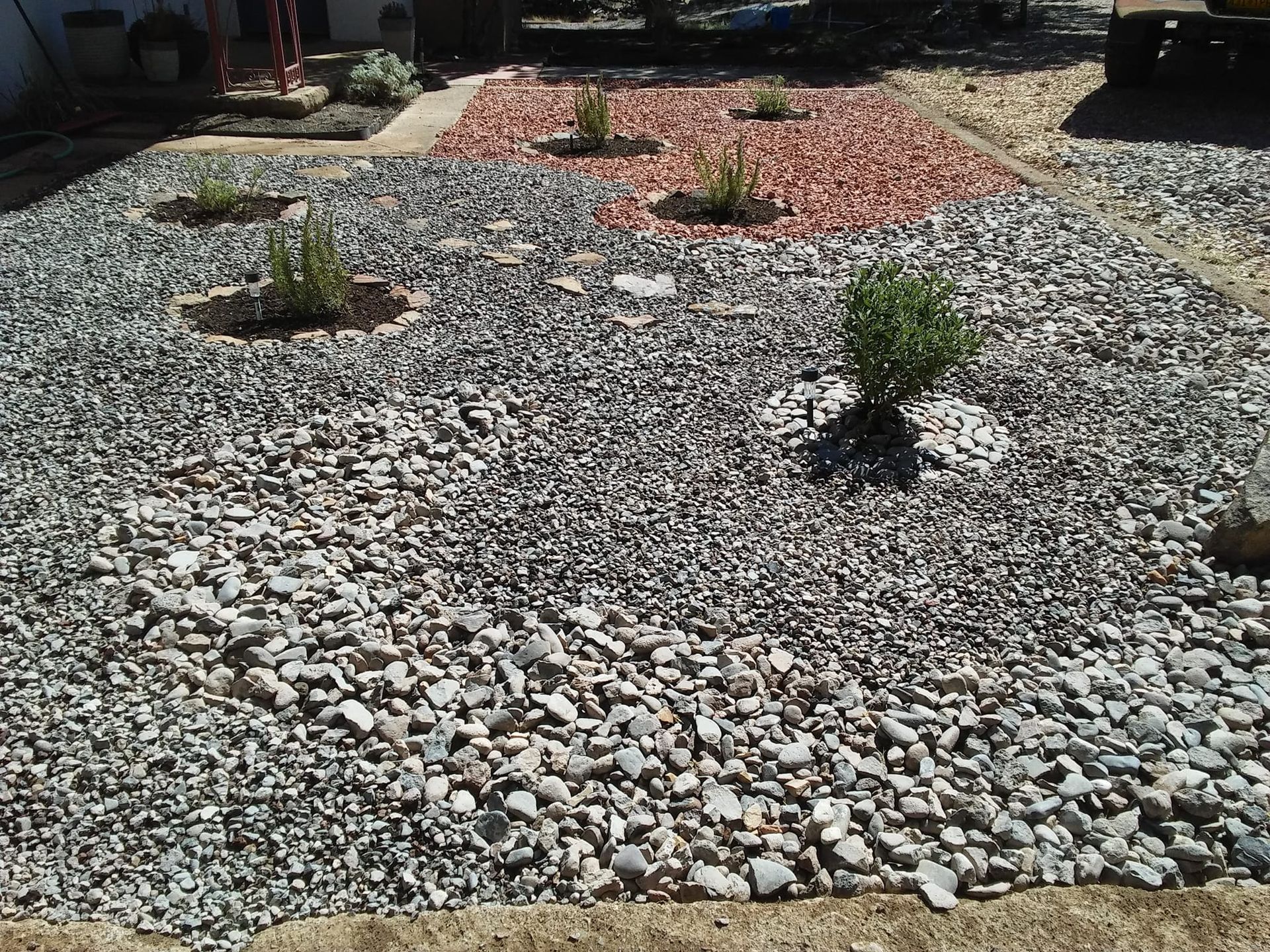 A pile of gravel with a few plants in the middle