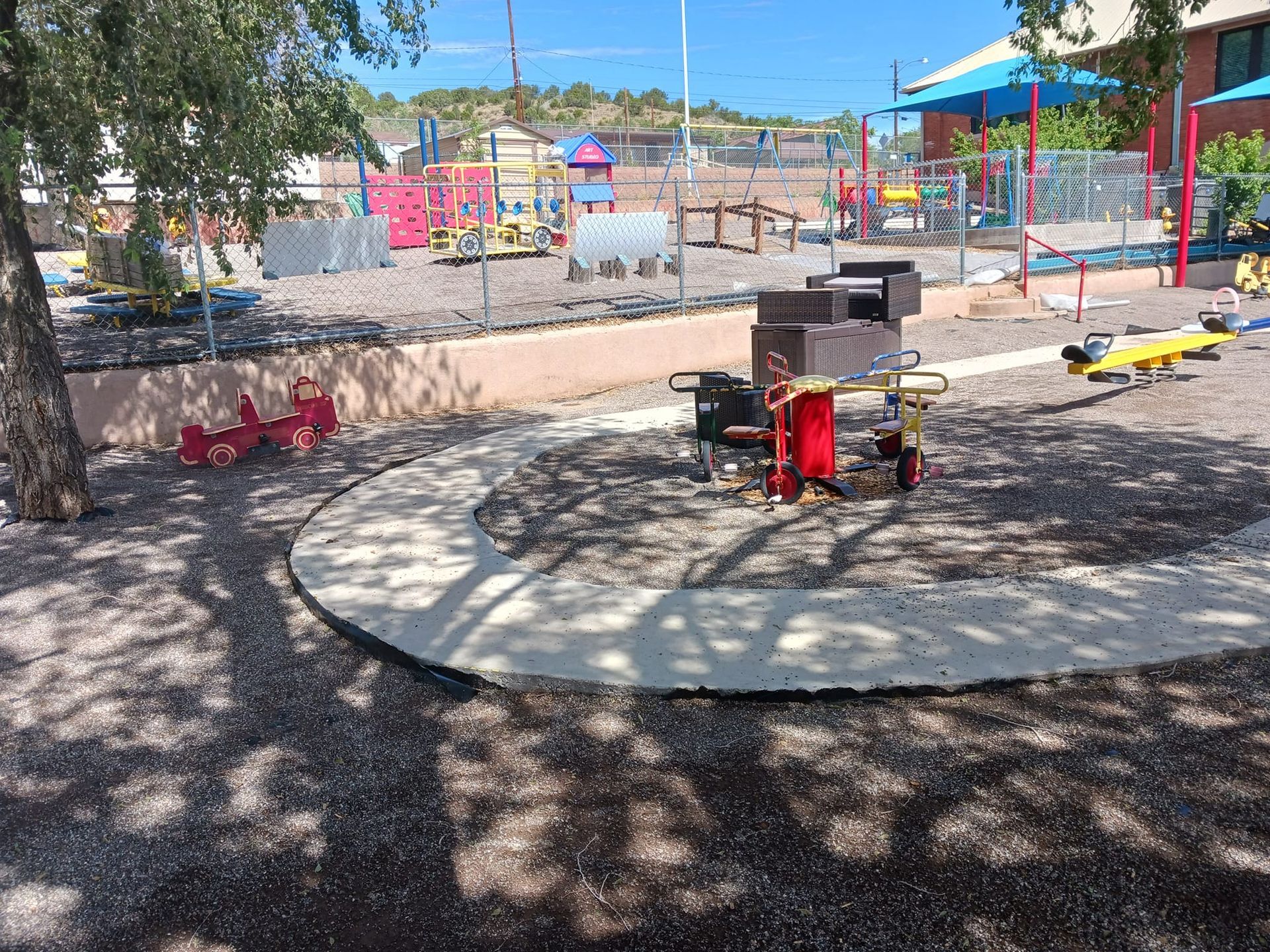 A playground with a table and chairs in the middle of it.