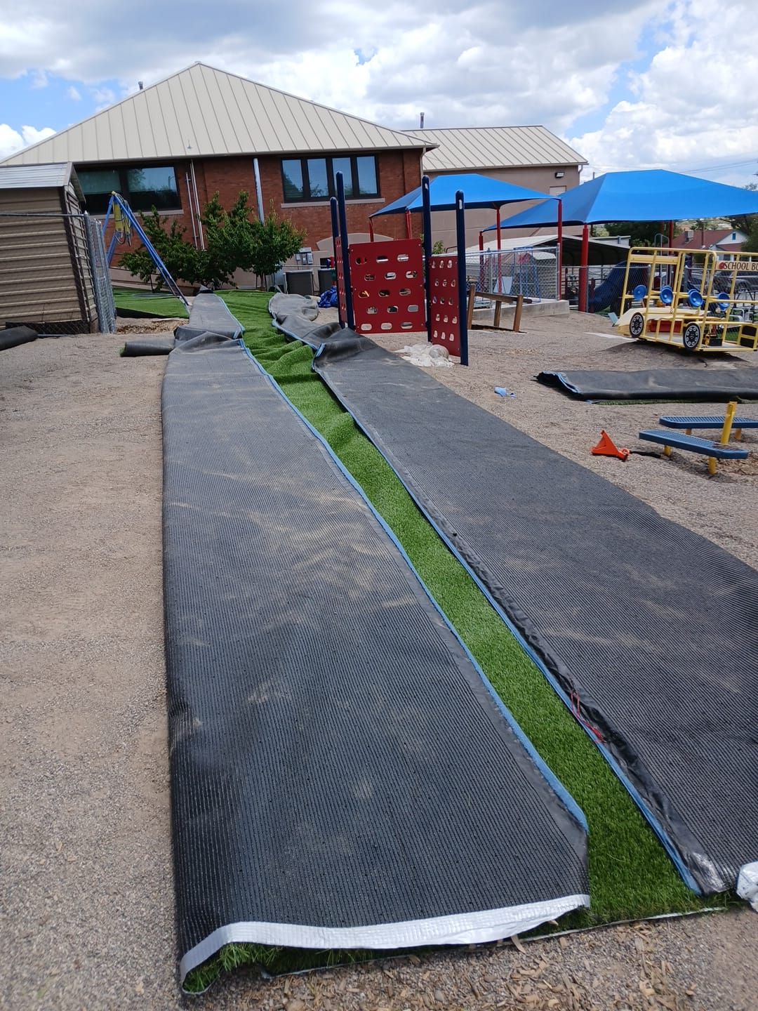 A playground is being built and the grass is being rolled out
