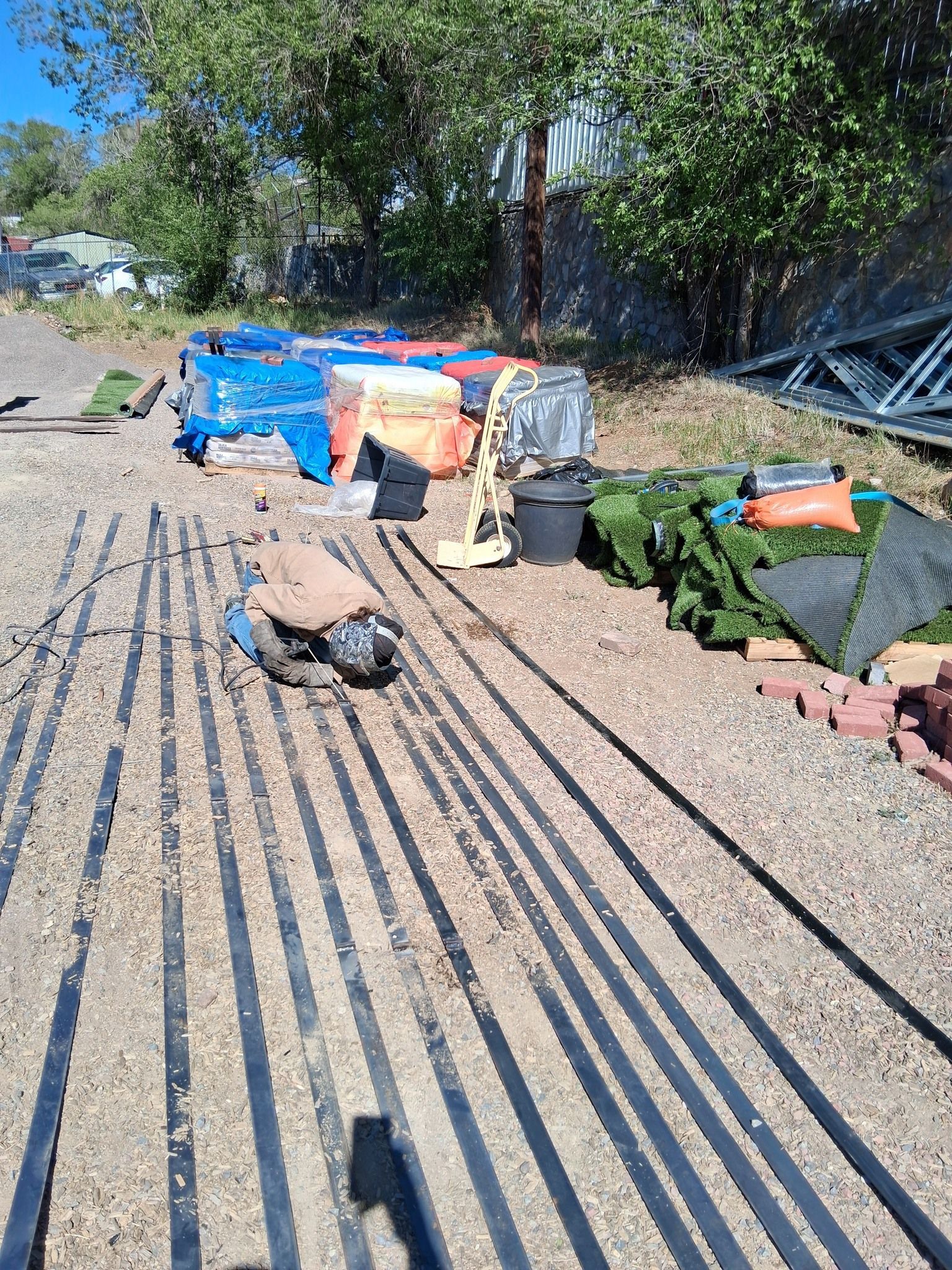 A row of black lines on a dirt road.