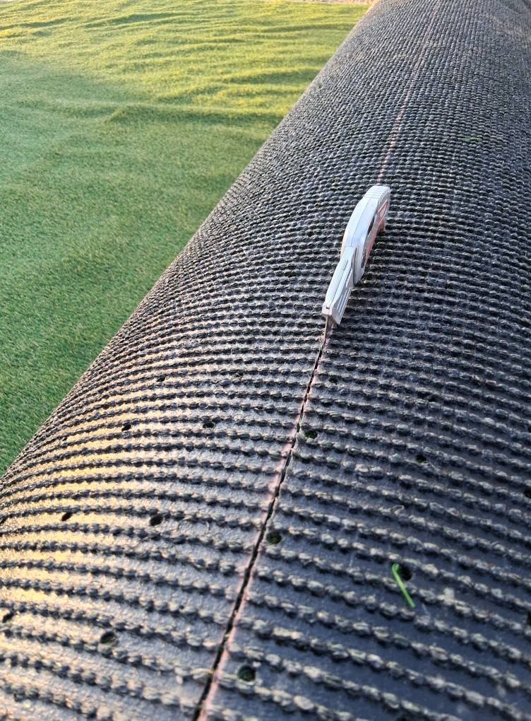 A piece of tape is laying on top of a piece of carpet.
