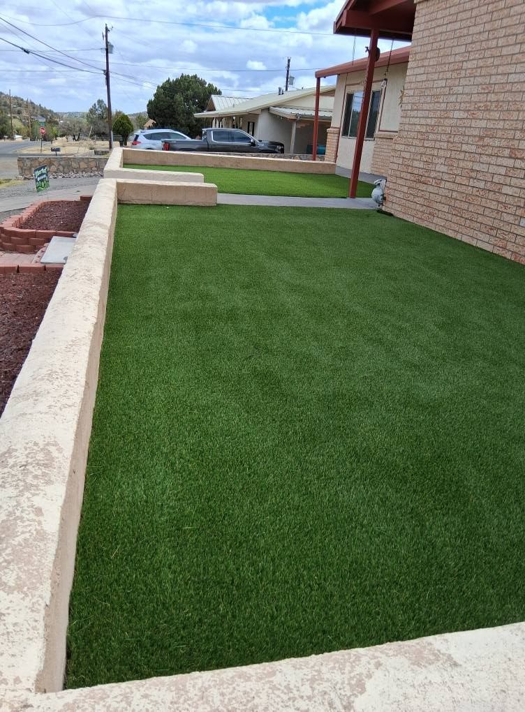 A large lawn with a brick building in the background