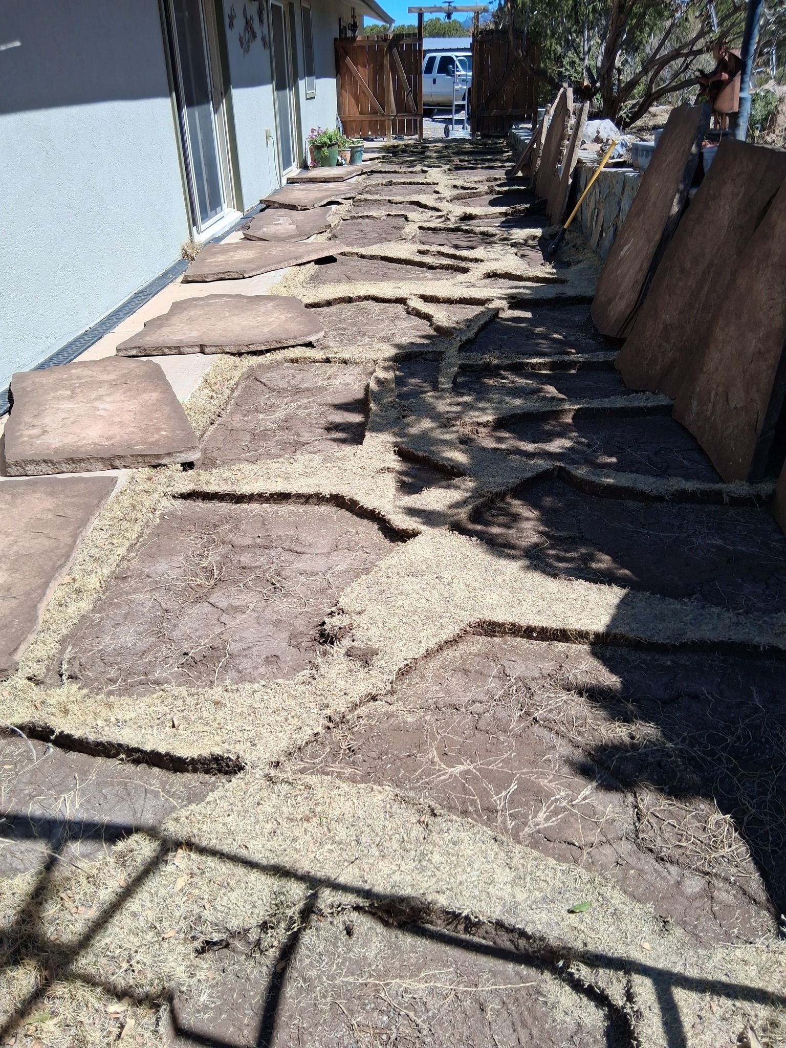 A stone walkway is being built in front of a house.