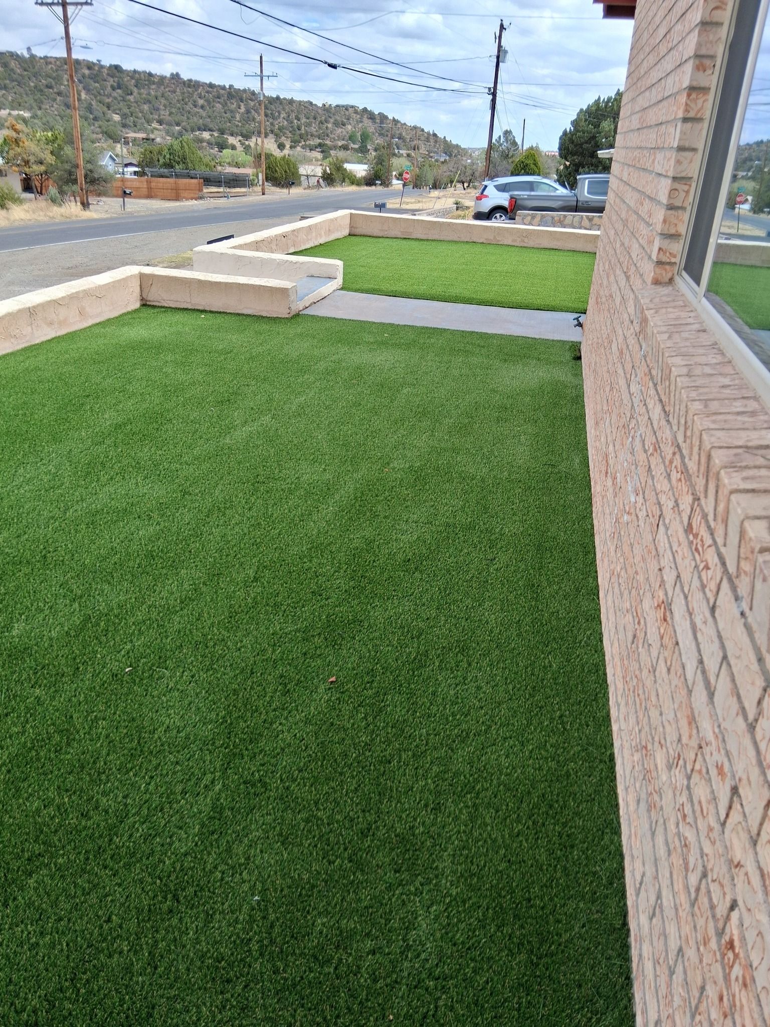 A brick building with a lush green lawn in front of it.