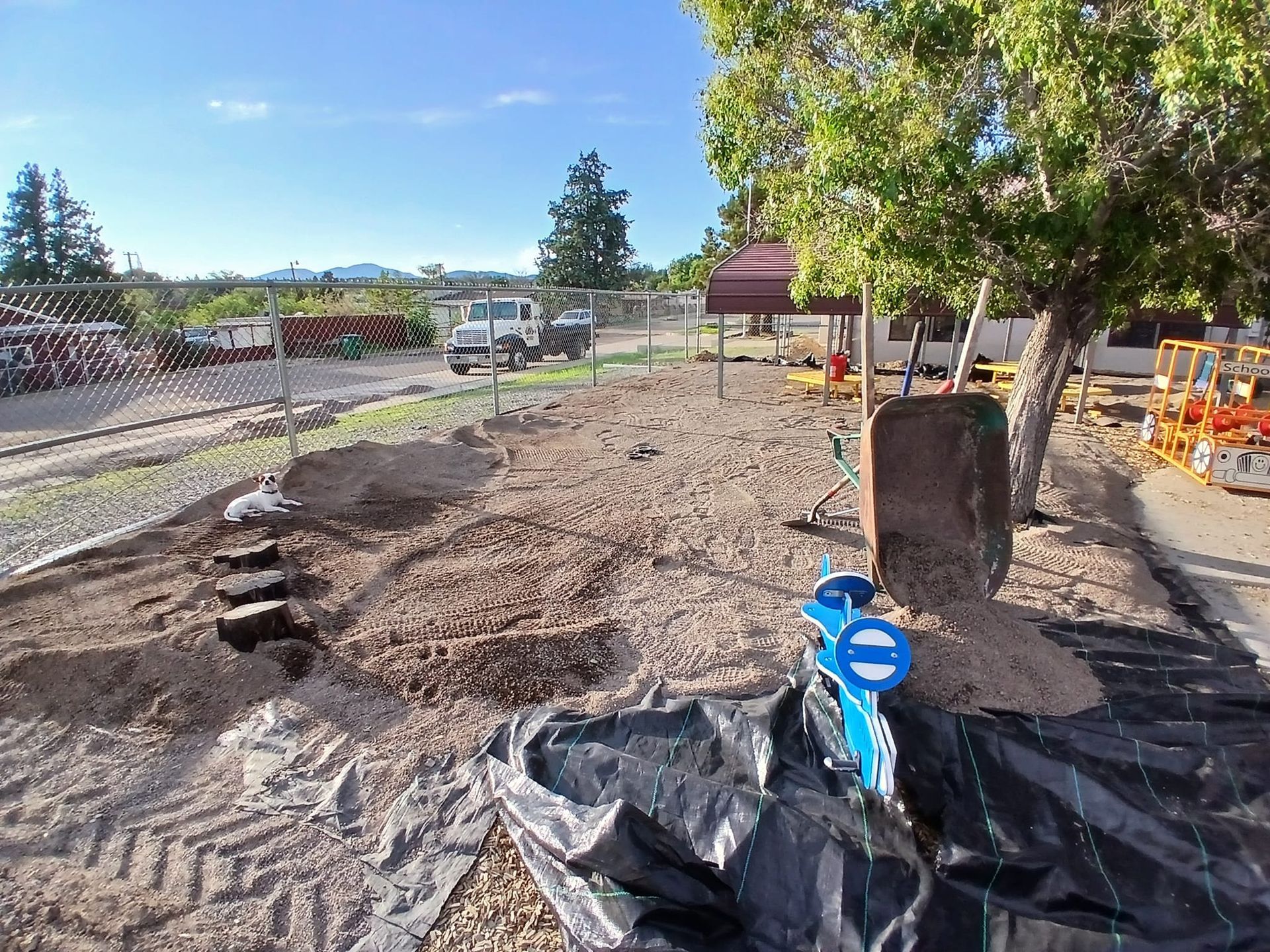 A shovel is sitting in the middle of a dirt field.