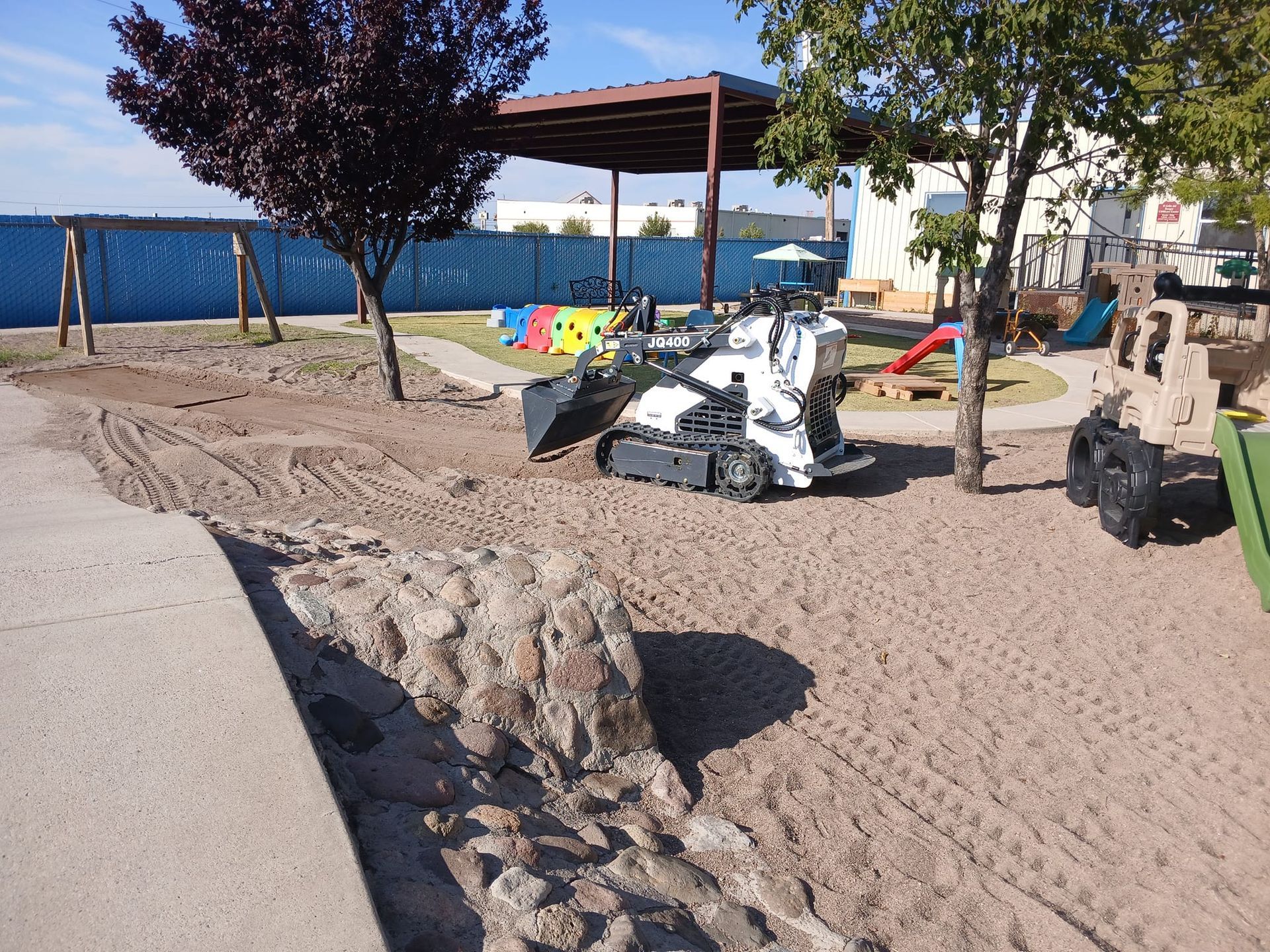 A bulldozer is moving dirt in a playground