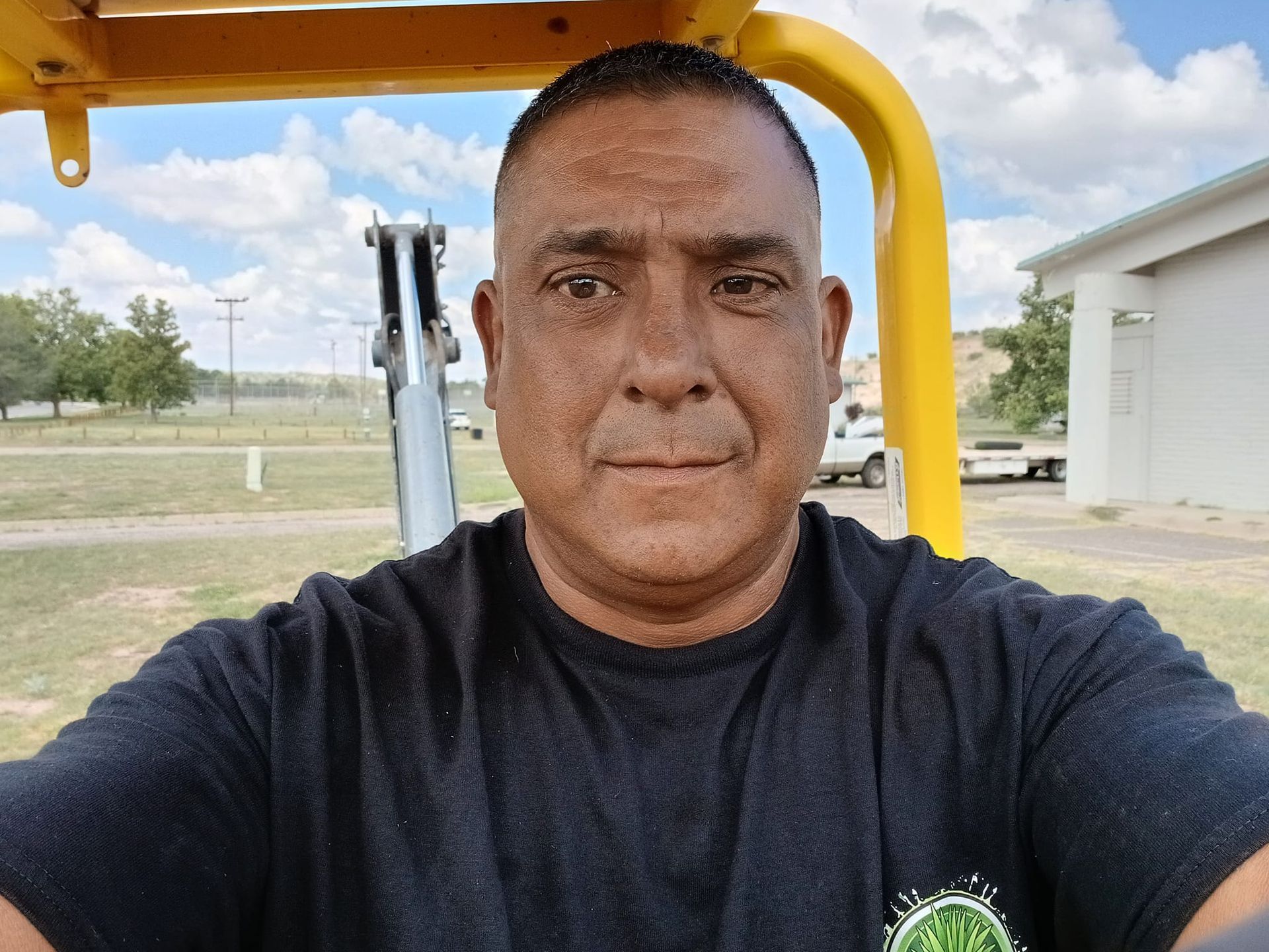 A man in a black shirt is sitting in a yellow vehicle.