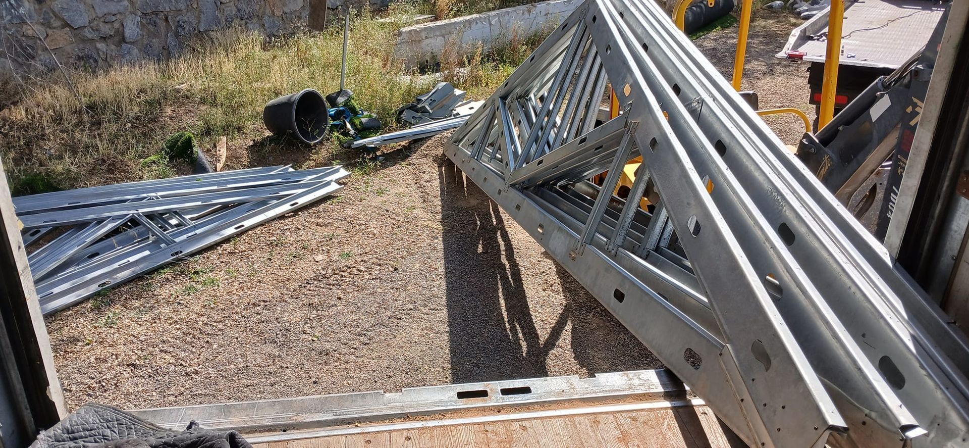 A bunch of metal pieces are stacked on top of each other on the ground.