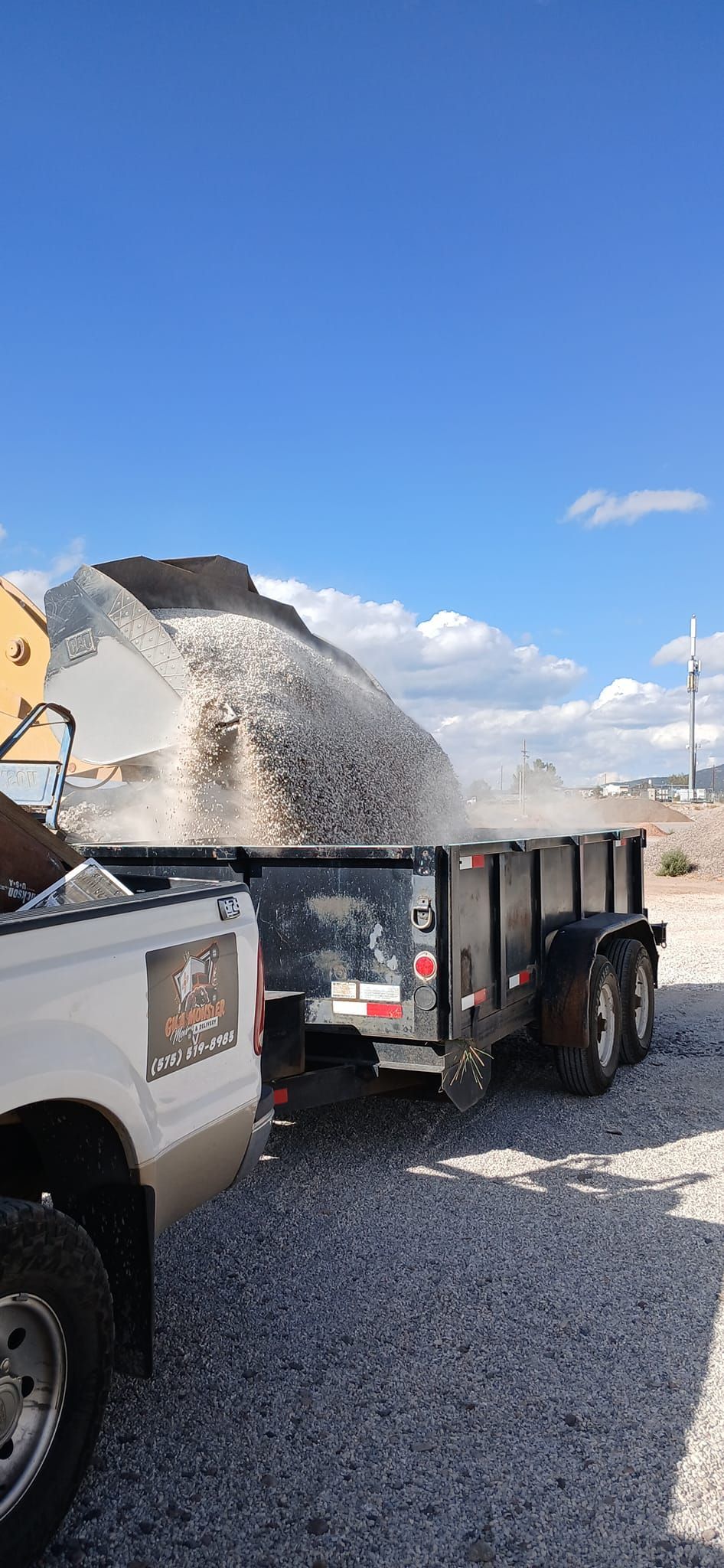 A truck is pulling a trailer full of gravel.