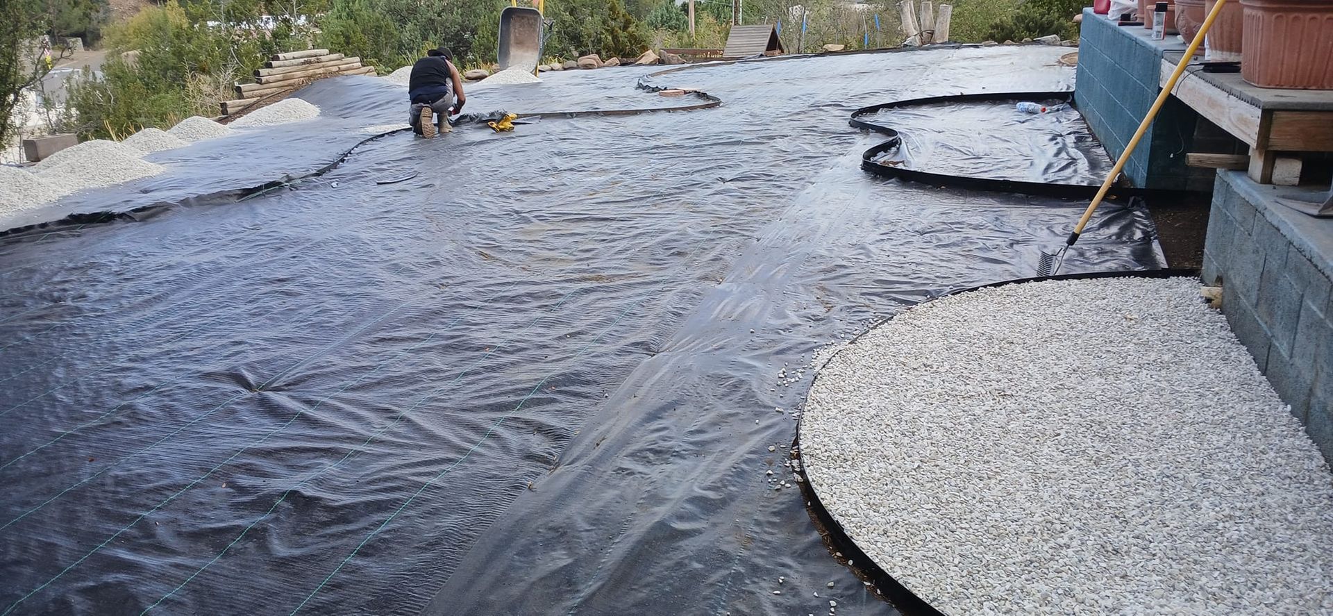A man is standing on a concrete surface with a broom.