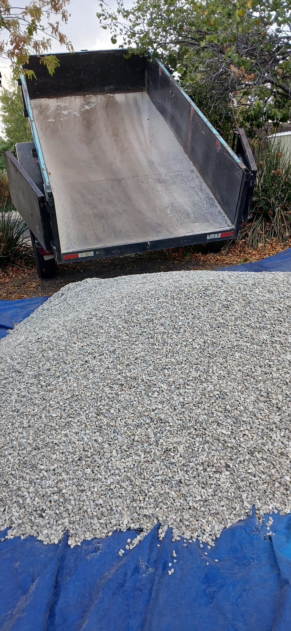 A dump truck is sitting on top of a pile of gravel.