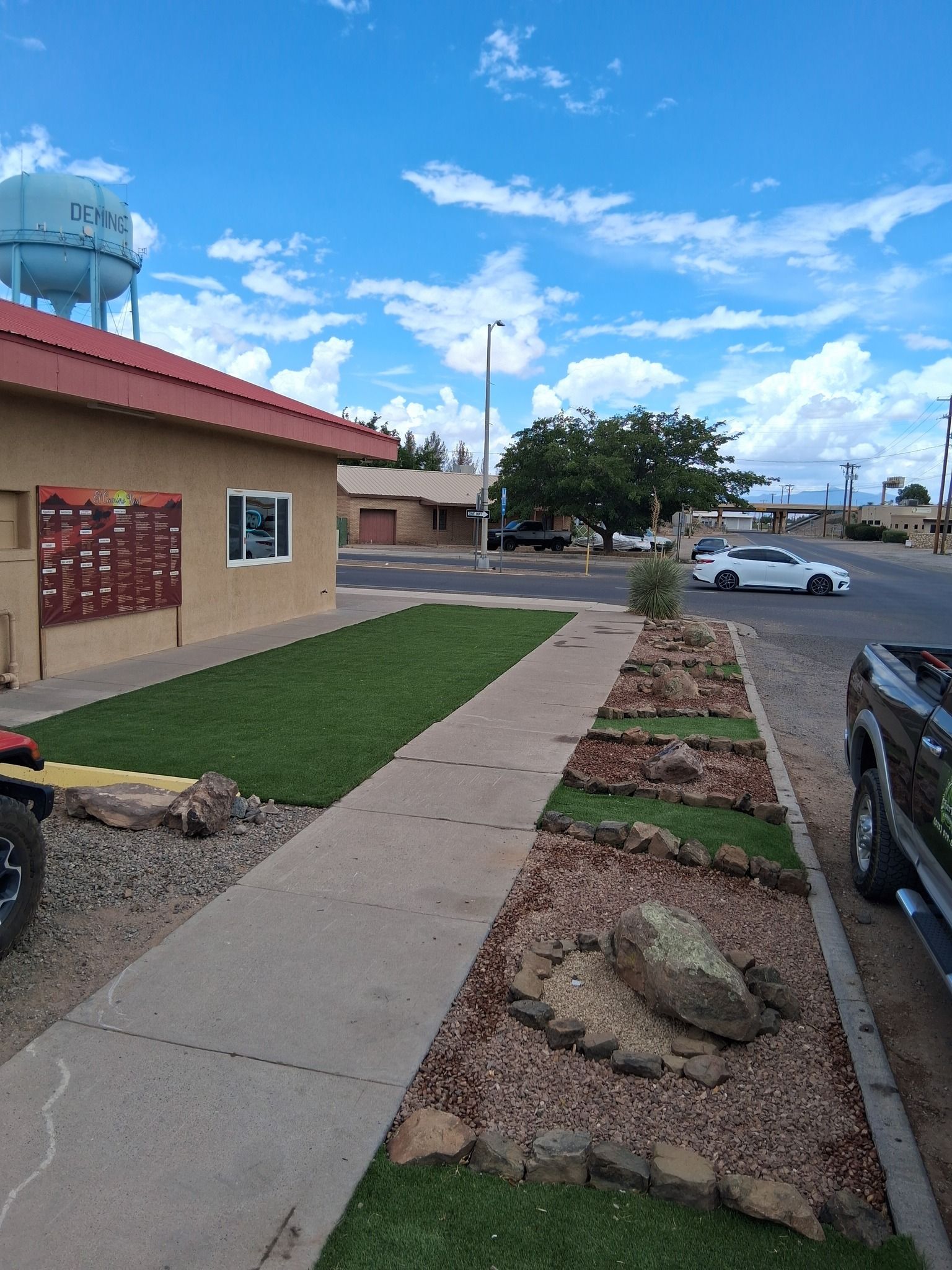 A truck is parked in front of a building with a water tower in the background.