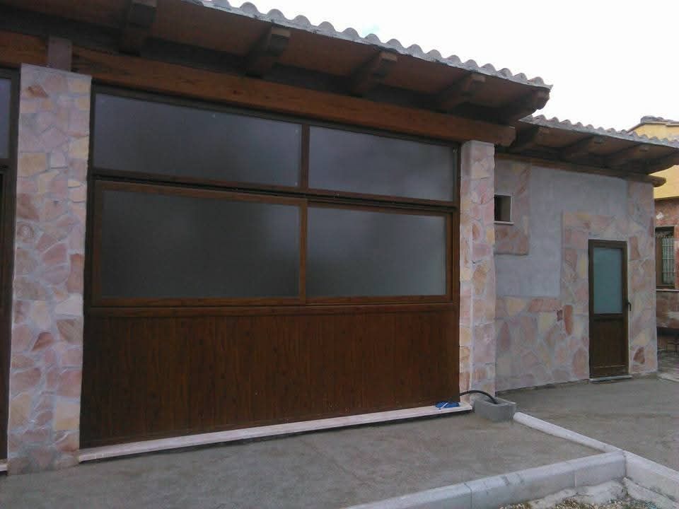 Soggiorno con ampie finestre, due divani, due poltrone, lampade e un tavolino da caffè.