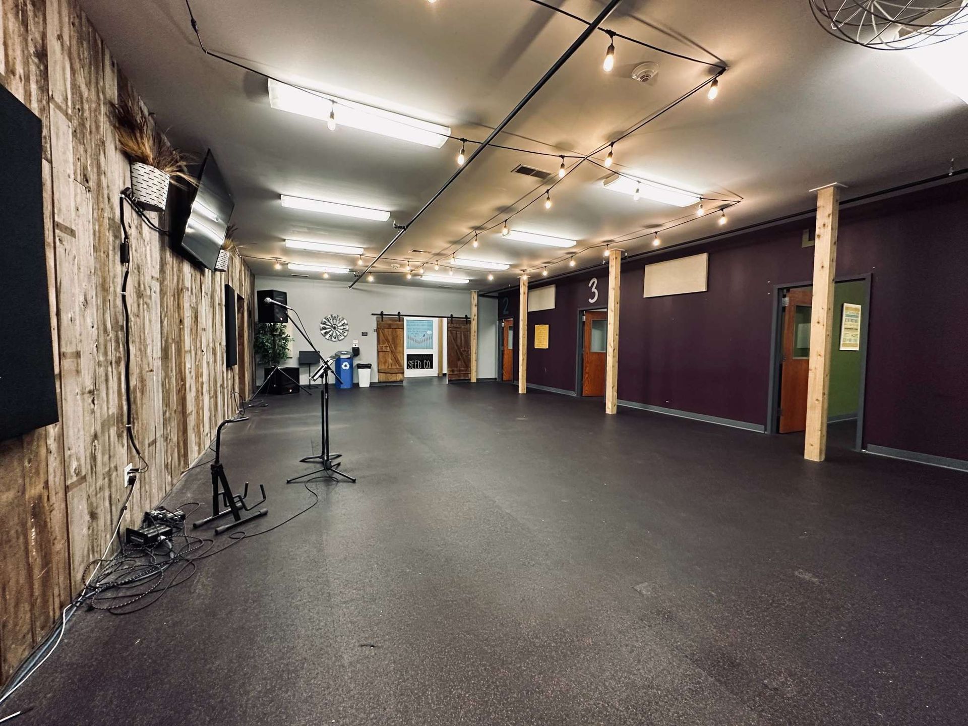 A large empty room with purple walls and a black floor