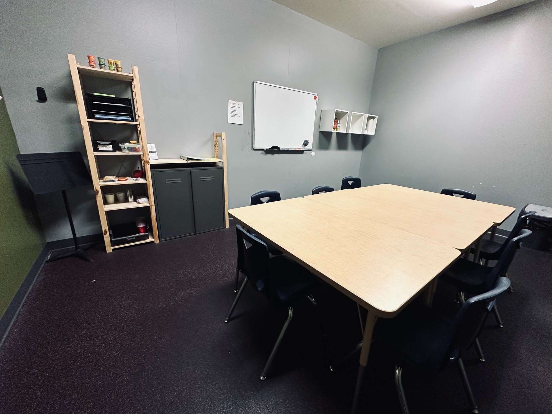 A conference room with a table and chairs and a whiteboard.
