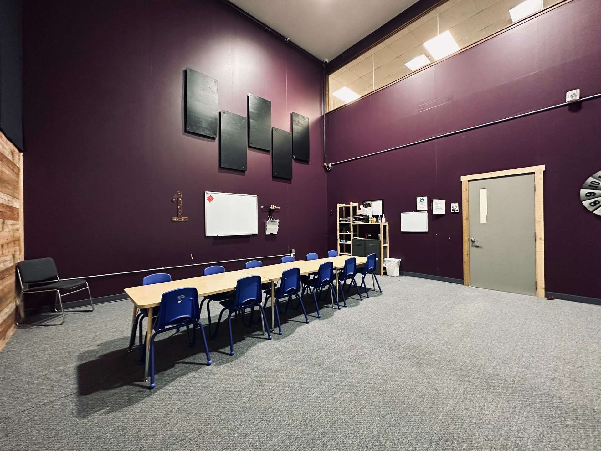 A long table and chairs in a room with purple walls.