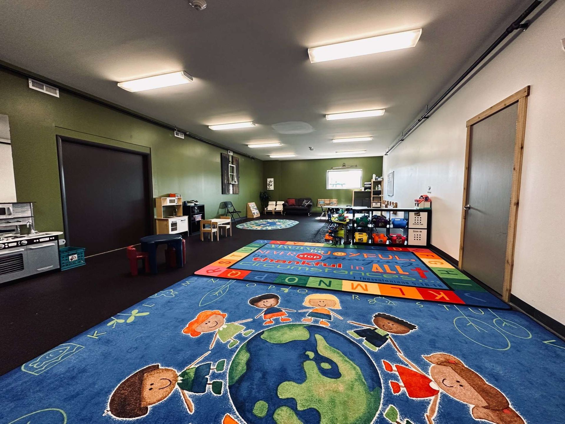 A large room with a colorful rug and a globe on the floor.